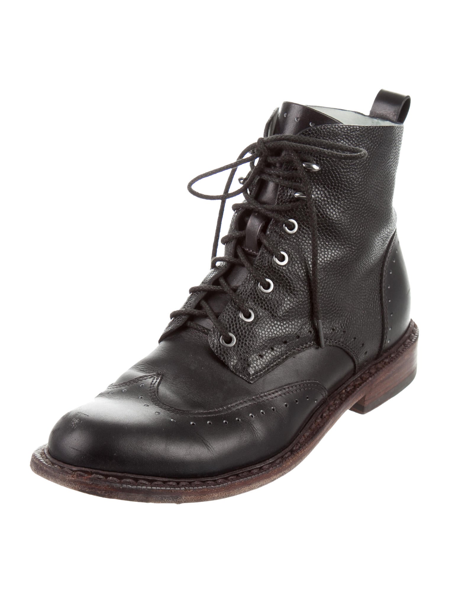 All Listings Black leather ankle boots detailed with classic brogue wingtip perforation, for an subtle hybrid look. These mixed texture boots slip on, and are designed with elasticized panels at the sides for a snug fit.